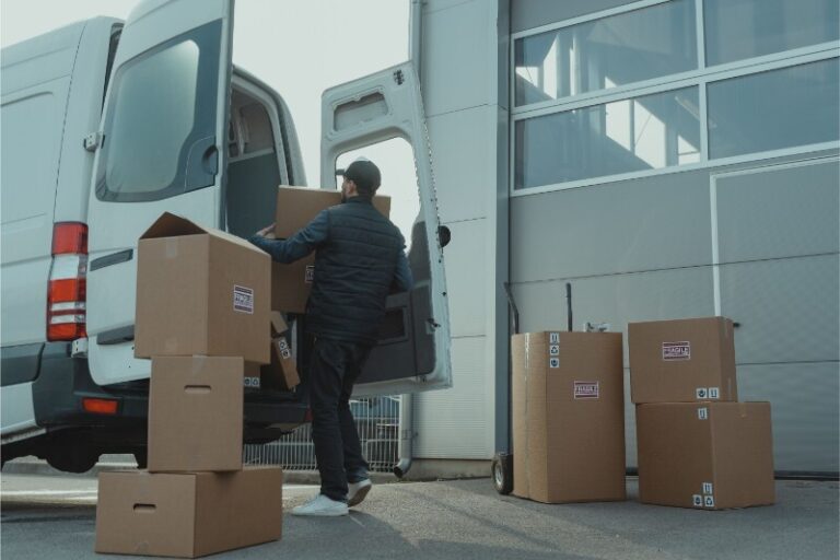 A junk removal crew sorting household items into separate donation, recycling, and trash bins on a residential driveway in Hemet, California.